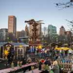 A group of people are sitting at tables at an outdoor market in Federal Hill, Baltimore.