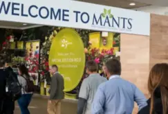 People enter an event space under a sign that reads 